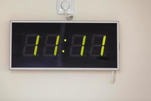 nero digitale orologio su un' bianca sfondo mostrando tempo undici ore undici minuti foto