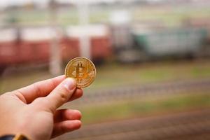 mano Tenere d'oro bitcoin virtuale i soldi treno foto