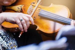 il mano di il ragazza giocando il violino nel buio colori foto