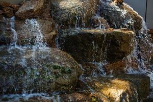 vicino su di acqua spruzzi su rocce a partire dal un' cascata foto