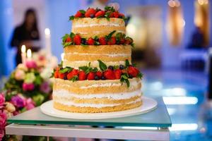 nozze torta con Aperto biscotto pasticcini, crema e frutta. mirtilli, fragole, lamponi, rosso ribes. foto