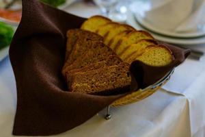 bianca pane e nero pane. affettato pane su il servendo tavolo nel un' di vimini cestino con bianca salsa. semplice rurale cibo. cibo per colazione, pranzo e cena. foto