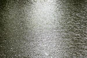 goccia di pioggia urto su increspatura acqua superficie foto