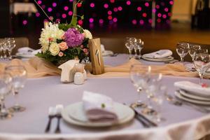 bellissimo tavolo ambientazione con vasellame e fiori per un' festa, nozze ricezione o altro festivo evento. cristalleria e posate per catering evento cena. foto