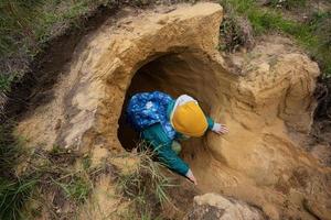 ragazzo con zaino Esplorare calcare pietra grotta a montagna. foto