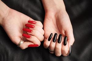 mani di un' giovane ragazza con nero e rosso manicure su Chiodi foto