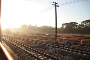 al di fuori finestra Ferrovia brani nel il campagna con tramonto cielo foto