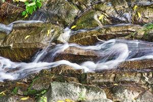 lungo esposizione di in esecuzione fiume su rocce foto