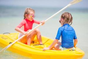 bambine adorabili godendo kayak in kayak giallo foto