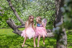 poco adorabile ragazze con farfalla Ali su fioritura Mela albero foto