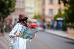 giovane donna guardare a turistico mappa della città. contento ragazza godere vacanza vacanza nel Europa. foto