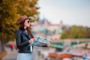 contento giovane donna con un' città carta geografica nel città. viaggio turista donna con carta geografica all'aperto durante vacanze nel Europa. foto