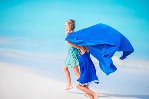 poco ragazze avendo divertimento godendo vacanza su tropicale spiaggia con bianca sabbia e turchese oceano acqua foto