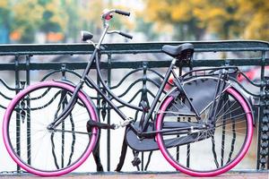 rosa bicicletta su il ponte nel amsterdam, Olanda. bellissimo Visualizza di canali nel autunno foto