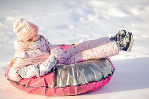 adorabile poco contento ragazza slittino nel inverno nevoso giorno. foto