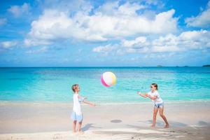 poco adorabile ragazze giocando con palla su il spiaggia foto