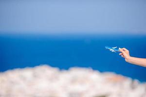 turista donna con giocattolo aereo nel mani sfondo il vecchio greco villaggio foto