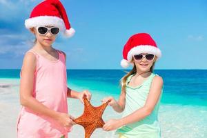 adorabile poco ragazze su Natale vacanze su il spiaggia foto