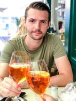 giovane ragazzo con un' bicchiere di aperto tintinnio bicchieri con un' bicchiere di il suo Amati ragazza foto