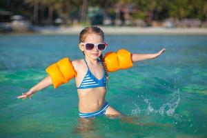 adorabile poco ragazza nel il mare su tropicale spiaggia vacanza foto