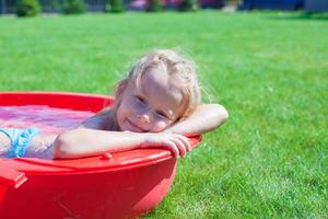 ritratto affascinante poco ragazza godendo sua vacanza nel il piscina all'aperto foto