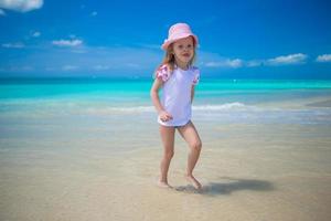 carino poco ragazza giocando nel superficiale acqua a Perfetto spiaggia foto