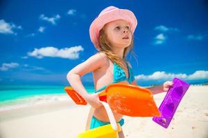 poco ragazzo giocando con spiaggia giocattoli durante tropicale vacanza foto
