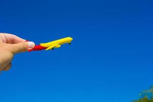 piccolo aereo nel femmina mano su sfondo di blu cielo foto