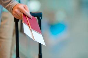 primo piano dell'uomo che tiene i passaporti e la carta d'imbarco all'aeroporto foto