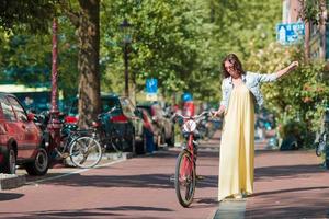 contento giovane donna su bicicletta nel amsterdam foto