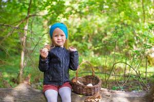 bambina raccogliendo funghi in una foresta di autunno foto