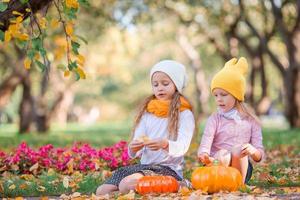 bambine adorabili al caldo giorno in autunno parco all'aperto foto