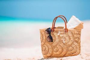 spiaggia Accessori - cannuccia Borsa, cappello e occhiali da sole su il spiaggia foto