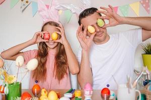 padre e il suo poco figlia pittura uova. contento famiglia preparazione per Pasqua. foto