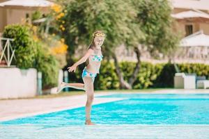 adorabile poco ragazza nuoto a all'aperto nuoto piscina foto