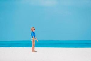 adorabile bambina divertirsi in spiaggia tropicale durante le vacanze foto