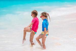 poco contento divertente ragazze avere un' lotto di divertimento a tropicale spiaggia giocando insieme. foto