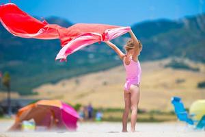 poco ragazza con spiaggia asciugamano durante tropicale vacanza foto