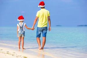 poco ragazza e contento papà nel Santa cappello durante spiaggia vacanza foto