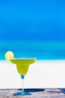 gustoso cocktail verde sulla spiaggia bianca tropicale foto