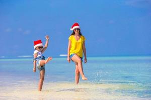 poco ragazza e giovane madre nel Santa cappello durante spiaggia vacanza foto