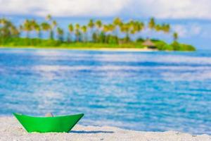 colorato carta barca su tropicale bianca spiaggia all'aperto foto