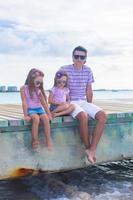 famiglia di tre seduta su di legno bacino godendo oceano Visualizza foto