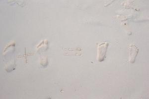 famiglia impronte su il bianca sabbia spiaggia foto