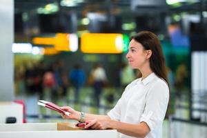 donna con passaporti e imbarco passa a il davanti scrivania a aeroporto foto