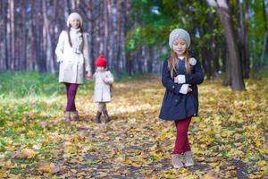 poco carino ragazze e giovane madre nel autunno parco avere divertimento foto