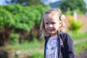 carino poco ragazza in piedi all'aperto e ridendo foto