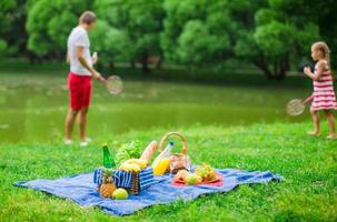 cestino da picnic con frutta, pane e bottiglia di vino bianco foto