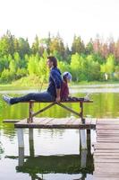 giovane papà e poco ragazza pesca su il lago foto