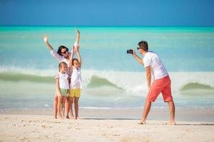 famiglia di quattro assunzione un' autoscatto foto su loro spiaggia vacanze. famiglia spiaggia vacanza